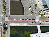 Luftaufnahme der städtischen Geometrie, wo moderne Architektur auf ruhiges Wasser trifft, durchzogen von pulsierenden, rot gesäumten Straßen, die in der Nähe des Osloer Opernhauses belebt sind, Oslo, Oslo, Norwegen.