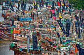 Patuakhali, Bangladesh - 05 September 2019: View of a colorful fleet of fishing boats adorned with vibrant flags, creating a lively spectacle against the river's muted tones.