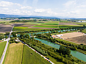Luftaufnahme der grünen Wasserwege, die sich durch die Felder schlängeln, eine ruhige Szene unter einem weiten Himmel, die die natürliche Schönheit des Flusses Aare in der Schweiz unterstreicht.