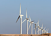 View of stark white wind turbines stand tall against the boundless azure sky, a testament to renewable energy in the arid landscape, Zaafarana, Red Sea Governorate, Egypt.