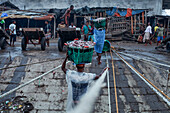 Chattogram, Bangladesh - 28 November 2019: View of the vibrant fish market, where the day's fresh catch is carried on heads amidst the bustling harbor's rustic charm.