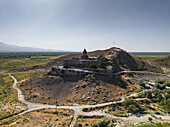 Luftaufnahme des Klosters Khor Virap auf einem Hügel, dessen uralte Steine vor der Kulisse des majestätischen Berges Ararat warm leuchten, Khor Virap, Provinz Ararat, Armenien.