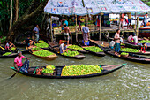 Atghar Kuriana, Bangladesh - 28 July 2017: View of boats laden with vibrant green fruits clustered near a bustling market stall, reflecting the lively trade along the waterway.