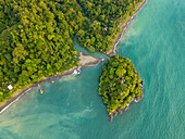 Luftaufnahme des leuchtend grünen Waldes und des türkisfarbenen Ozeans, eine kleine Insel an der Flussmündung, die einen atemberaubenden Kontrast zur Schönheit der Natur bildet, Nuquí, Choco, Kolumbien.