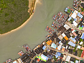 Aerial view of boats nestled by colorful buildings where the river meets the sea, a vibrant tapestry of life unfolds from above, Sam Roi Yot, Prachuap Khiri Khan, Thailand.