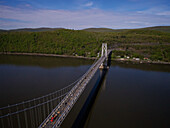 Luftaufnahme der Mid-Hudson Bridge, die sich über den ruhigen Fluss spannt und ferne Ufer unter einem ruhigen Himmel verbindet, Poughkeepsie, New York, Vereinigte Staaten.