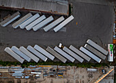 Aerial view of diagonally arranged freight trailers on pavement in an industrial area, creating a geometric top-down view of light and dark. Appleton, Wisconsin, United States.