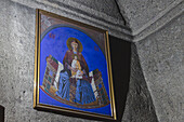 Blick auf eine gerahmte Ikone der Madonna mit Kind an einer rauen Steinwand, die in weiches Licht und Schatten getaucht ist, Geghard-Kloster, Mets Gilanlar, Provinz Ararat, Armenien.