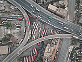 Aerial view of a bus terminal, where buses are parked, crossed by flyovers, creating a symphony of concrete and motion, Dhaka, Dhaka Division, Bangladesh.