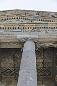 View of ancient carved stones and a solitary column reaching towards the sky in Garni, Kotayk Province, Armenia.