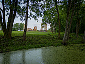 Aerial view of the crumbling ruins of Paulava Republic stand solemnly on a hill, framed by the emerald of the surrounding trees, Merkine, alininkai, Lithuania.