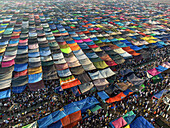 Tongi, Bangladesh - 04 February 2024: Aerial view of a vibrant tapestry of colorful tents stretching across the landscape, teeming with people below.