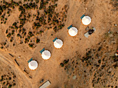 Aerial view of white domed tents standing out against the arid landscape of the Detwah lagoon, a stark contrast in the Yemeni terrain, Detwah lagoon, Socotra, Yemen.