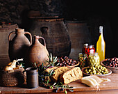 Mediterranes Stillleben mit Oliven, Brot und Tonkrügen