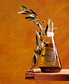 Glaskaraffe mit Olivenöl und ein Olivenzweig