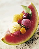 Früchte und Eiskugeln auf einer Scheibe Wassermelone