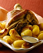 Knuckle of ham with apples and potatoes in cider