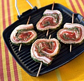 Rolled pork kebabs on grill