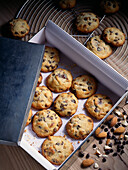 Chocolate Chip-Mandel Cookies auf Kuchengitter und im Geschenkkarton