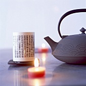 Teekanne, asiatischer Teebecher und Teelichte