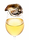 eine geöffnete Auster auf einem Glas Weißwein