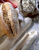 Gebackenes und ungebackenes Brot auf bemehlter Arbeitsfläche