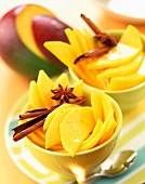 Dishes of fresh sliced mangoes with spices