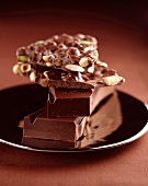 Dunkle Schokolade und Nussschokolade auf schwarzem Teller