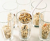 spooning muesli into glasses (filmed recipe: fromage frais with fruit and muesli)