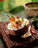 Chicken brochette with coconut milk rice in a coconut shell