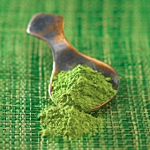 Matcha-Tee mit Löffel auf grüner Matte