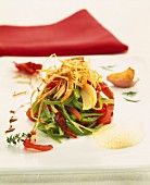 Salat mit Lauchstreifen, eingelegten Tomaten und frittierten Zwiebeln