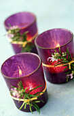 Mit Rosmarinblüten dekorierte, violette Windlichter