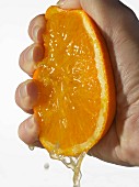 Eine Orange mit der Hand auspressen