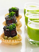 Pea soup in glasses and leek tartlets with sausage