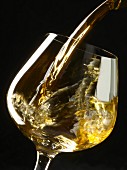 Weißwein in ein Glas einschenken