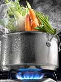 Steam cooking vegetables in a saucepan on a gas cooker