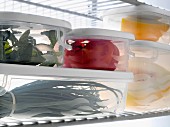 Tupperwares full of fresh products in the refrigerator