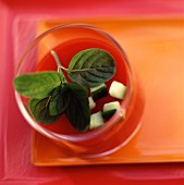 Tomatencremesuppe mit Basilikum und rohen Zucchiniwürfeln