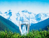 Glass of water with mountains in the background