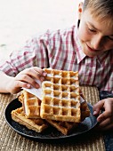 Child holding a waffle with sugar