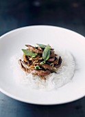 Sliced beef with Thai basil on a bed of rice vermicelli