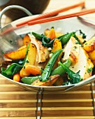 Chicken and spring vegetables cooked in a wok
