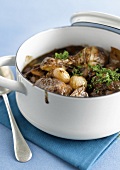 Casserole dish of capon cooked in red wine