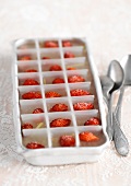 Ice cubes with a wild strawberry in each