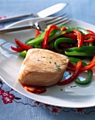 Thick piece of salmon with red and green peppers