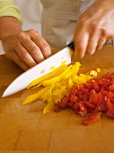 Dicing the yellow and red peppers
