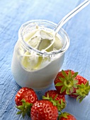Open yoghurt in a glass pot and strawberries