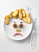 Plate of Langues de chat biscuits and candies in the shape of a sad face