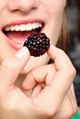 Woman eating a blackberry